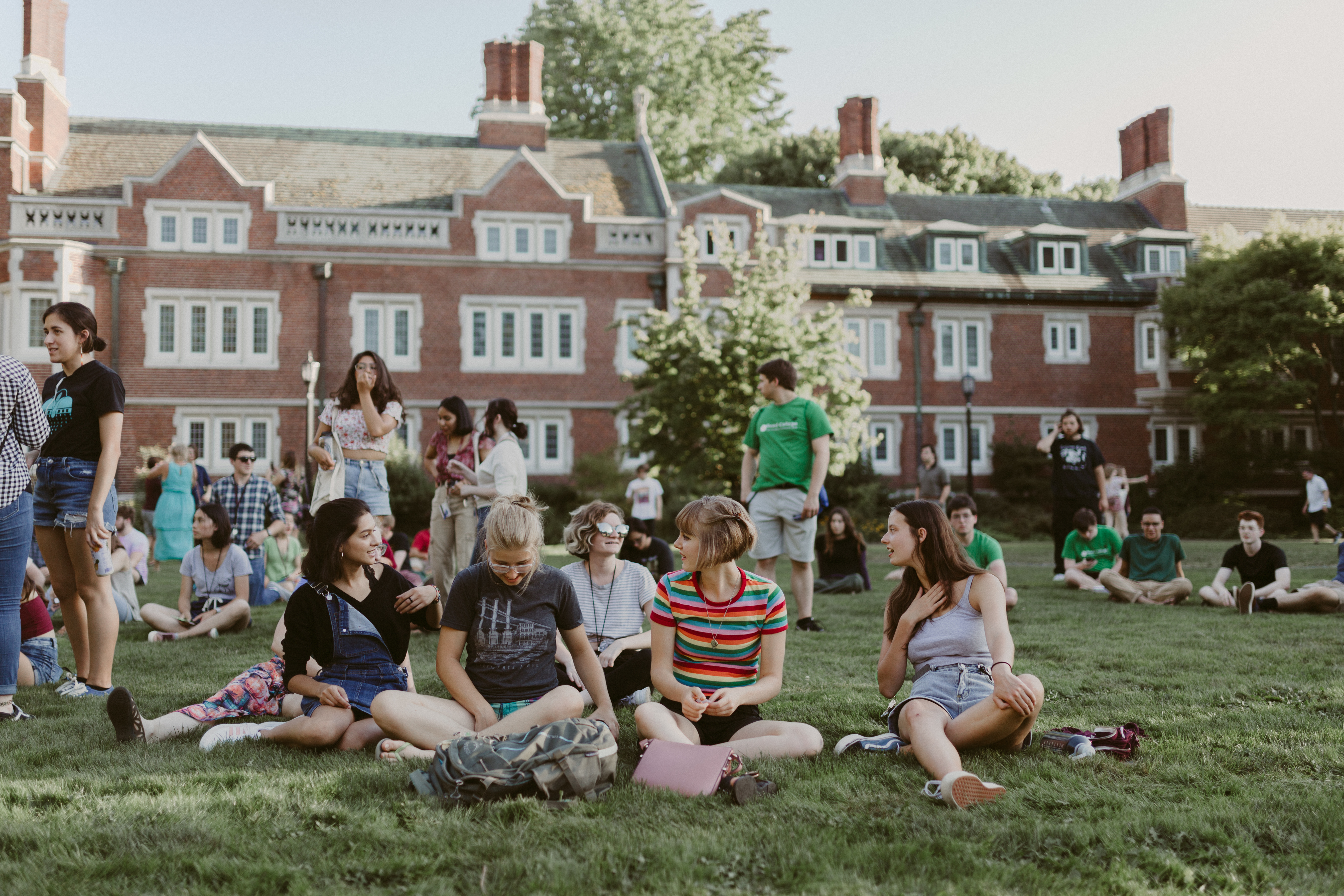 A small group of Reed students gathered around and chatting on the lawn in front of Eliot Hall.