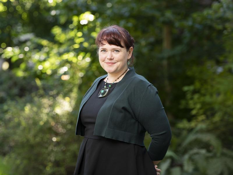 Photo portrait of Zajj Daugherty, Associate Professor of Mathematics, standing outside with trees in the background.