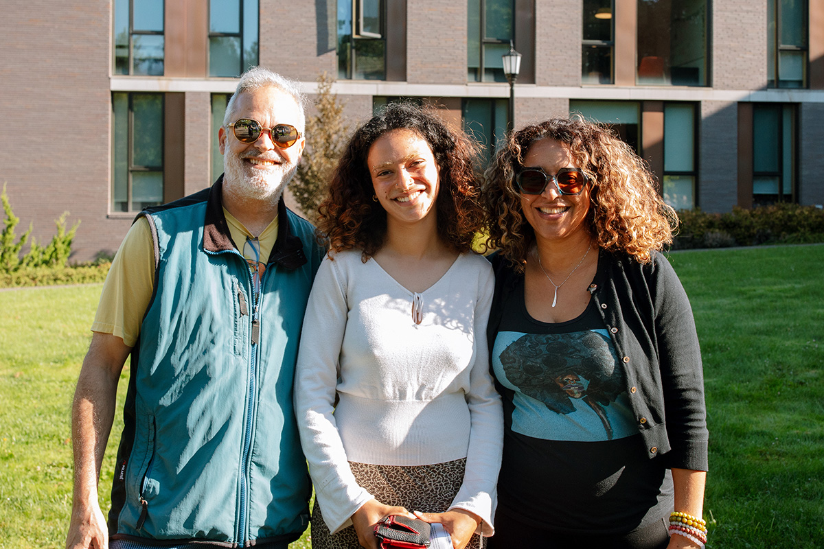 Parents posing with their student in front of Trillium residence hall