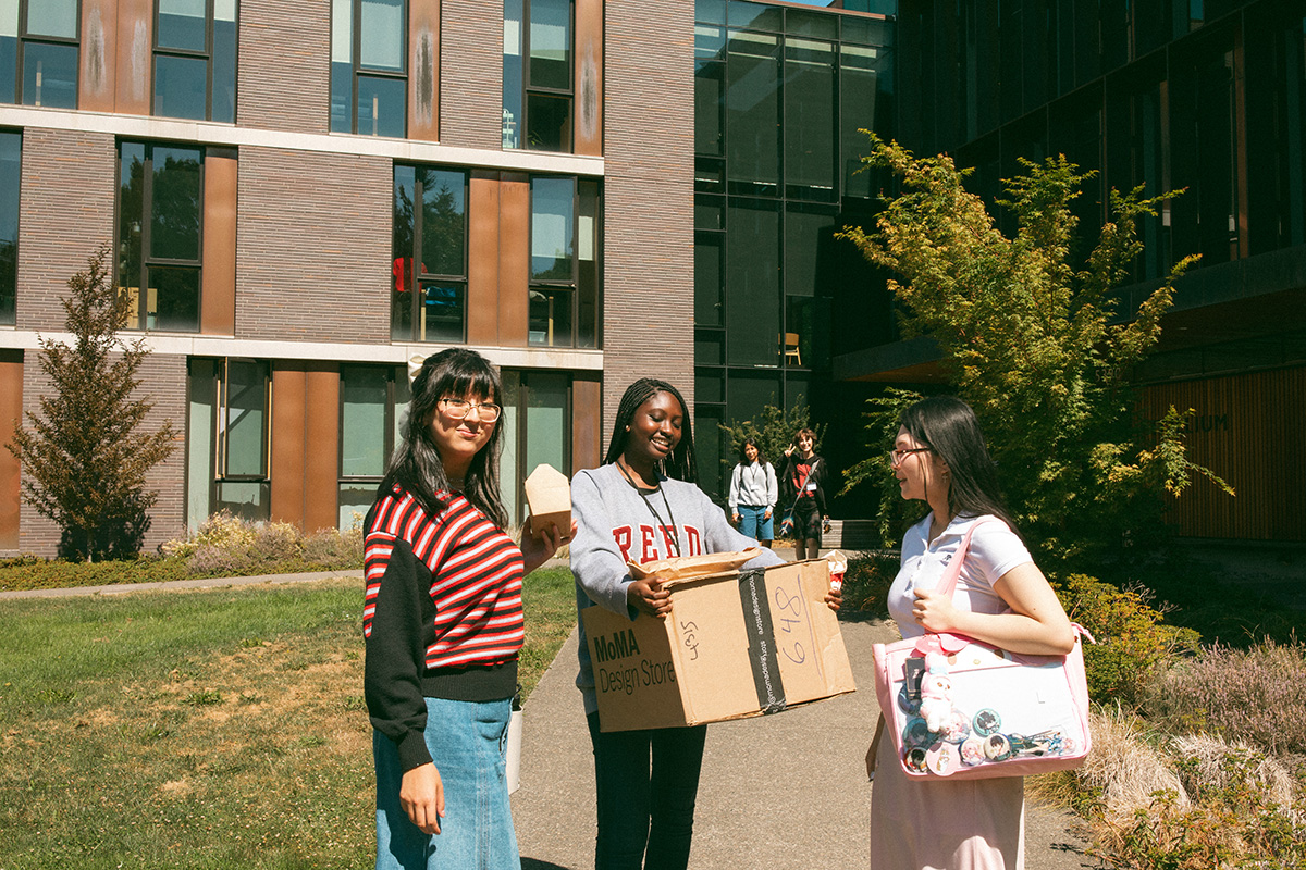 Students and families entering Trillium residence hall with food and boxes