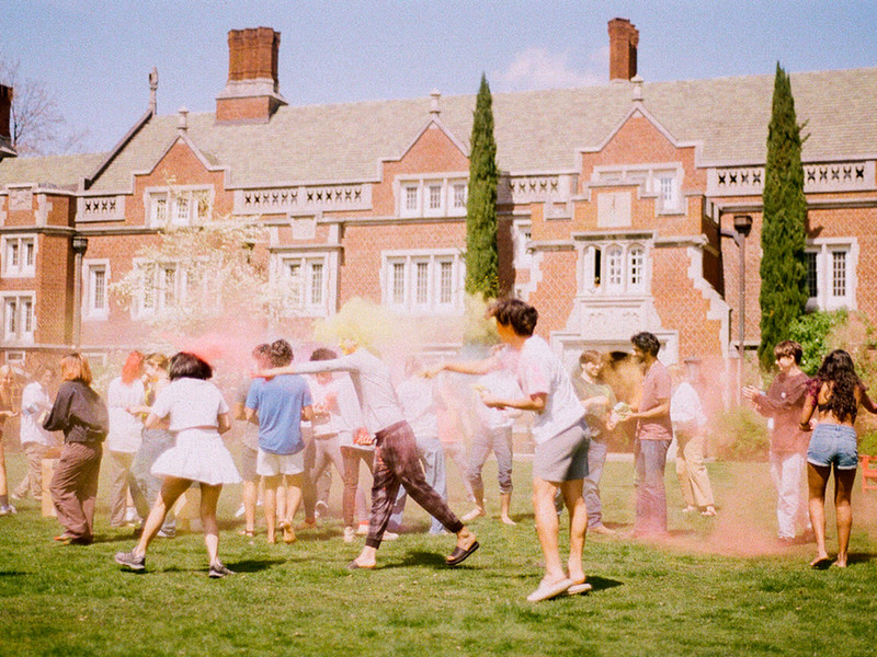 Student celebrating Holi in front of the Old Dorm Blocks