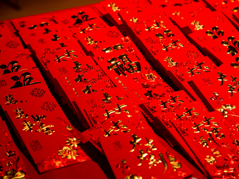 A pile of red li-xi envelops with gold characters