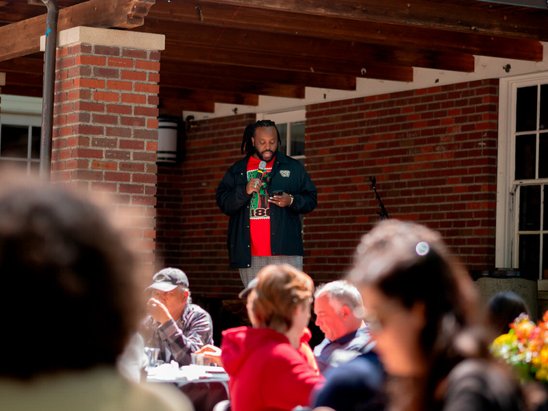 Karnell McConnell-Black speaking into a microphone while reading