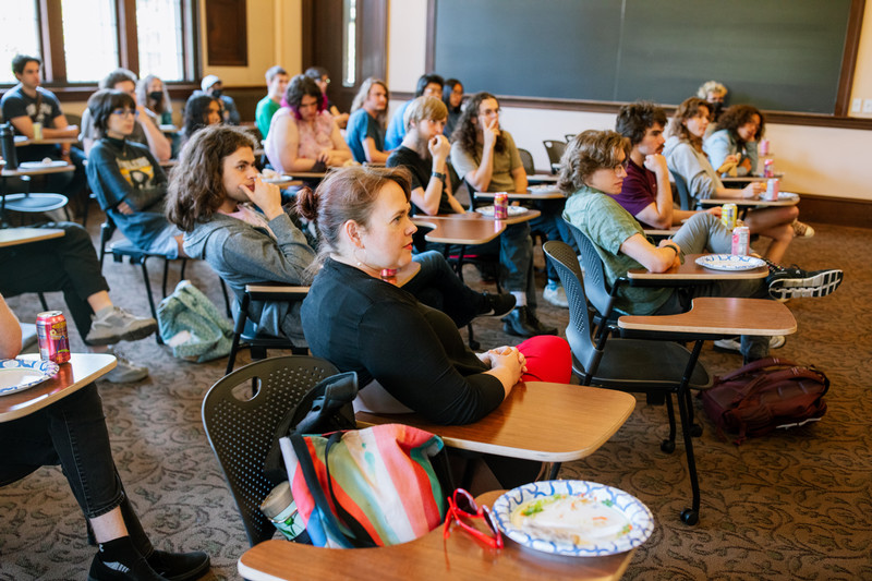 The audience of the summer lunch presentations listens attentively at desks