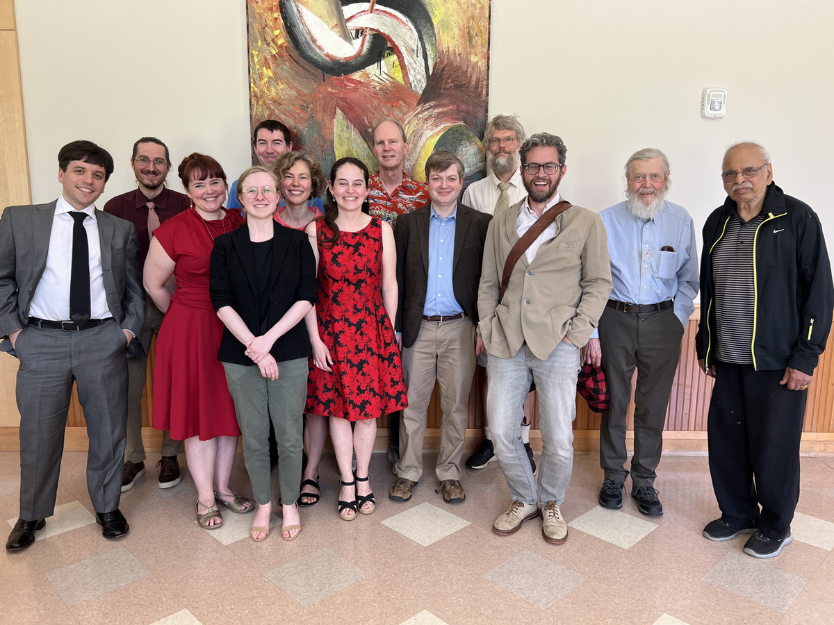 Faculty from the mathematics and statistics department pose for a group photo at an event honoring David Perkinson, pictured center.