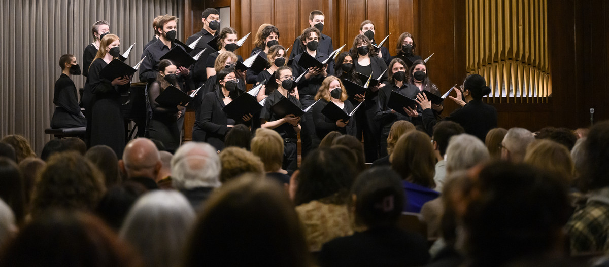 The Collegium Musicum in performance, a large group of singers dressed in black