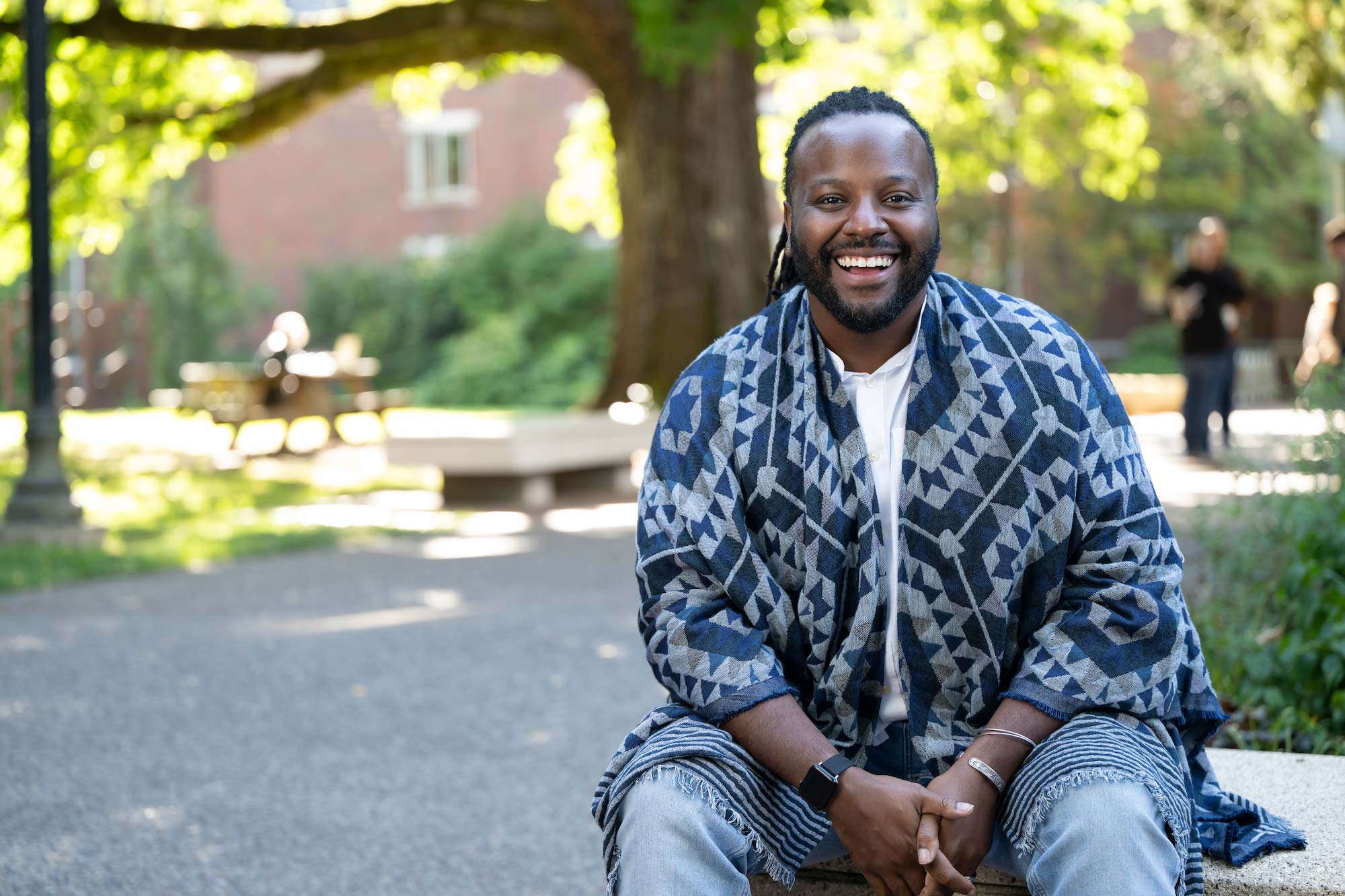 A photo portrait of Karnell McConnell-Black sitting outside on a bench.