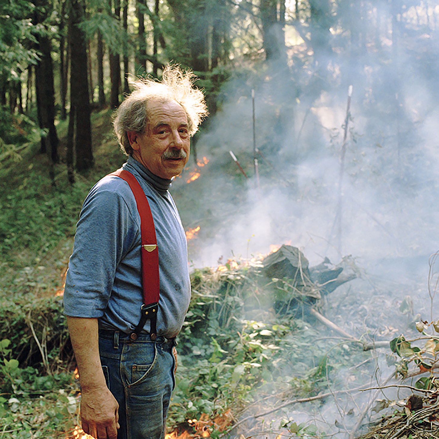 photo of Len in front of a forest scene with smoke and fire